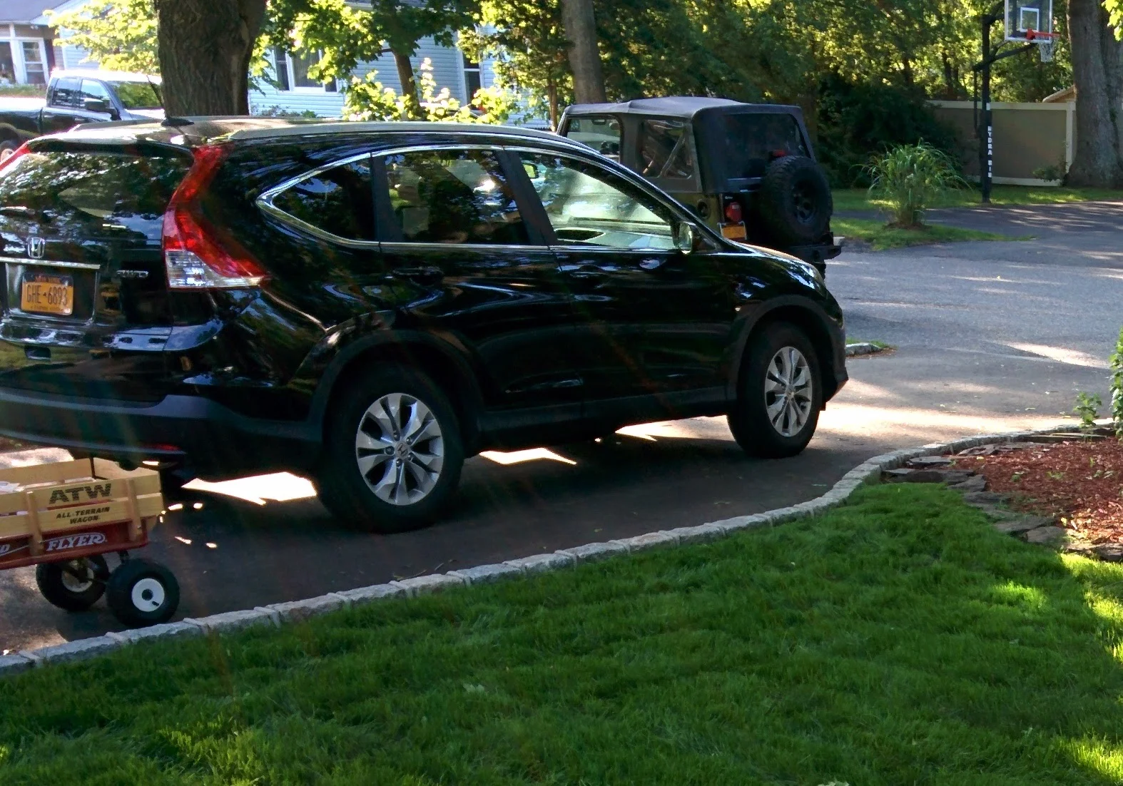Honda CR-V in black, parked in driveway with TJ Wrangler behind it